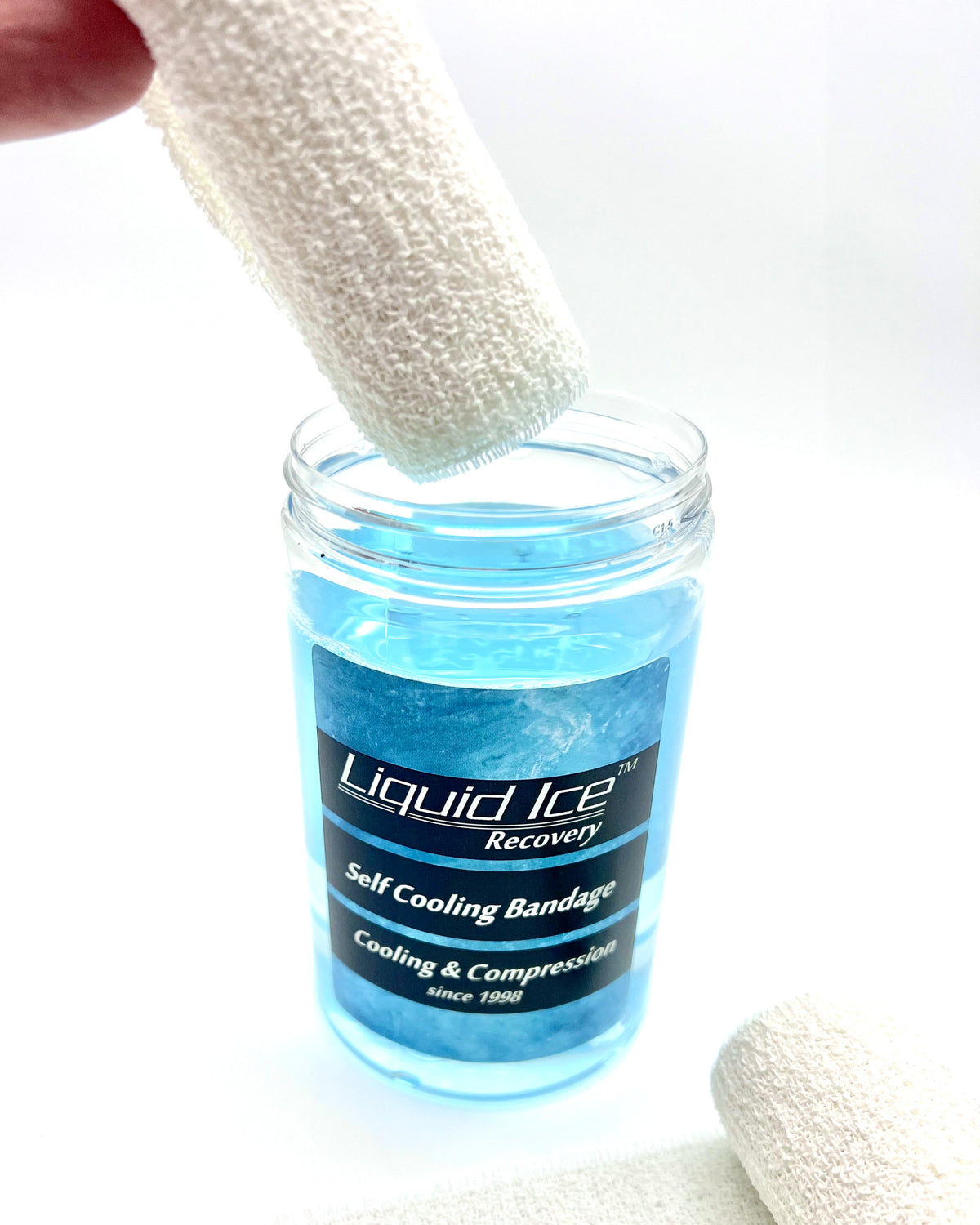 The bandage is lifted out of the can of Liquid Ice, soaked